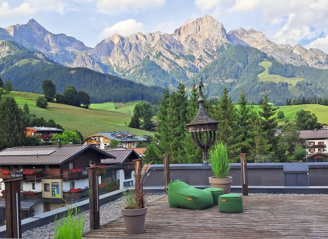 Im Liegestuhl genießt man von der Dachterrasse des Hotels Niederreiter den Ausblick auf Steinernes Meer bis hin zum Hochkönig. Bild: Bünnagel